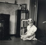 604418 Afbeelding van Ilona van der Linden, met een boek in haar hand, naast de boekenkast in de woonkamer van het huis ...
